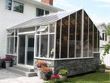 Gable Solarium or Peaked Solarium with faux stone pony wall, roof crests and sliding door.