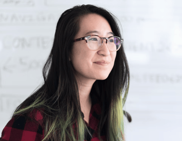 a woman with glasses and a plaid shirt