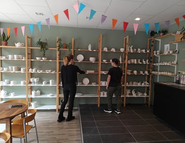 Customers browsing shelves of unpainted ceramic, choosing their favourite