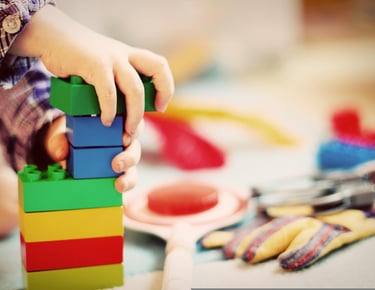 Toddler learning toys including stacking blocks, books, and educational puzzles.
