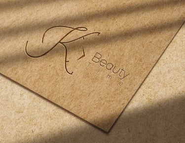 Elegant KT Beauty Time brand logo embossed on textured craft paper with natural leaf shadows.