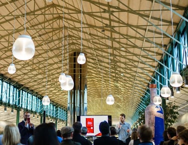 Inside of a large building with people participating at en event