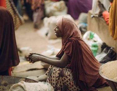 a woman in a red dress sitting on a pile of bags