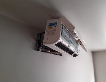 An open, wall-mounted air conditioner unit with its front cover lifted, revealing internal components and filters