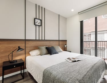 Sophisticated bedroom with natural walnut finishes, custom art pieces, and balanced design by SAVIA