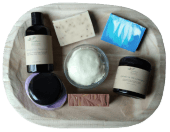 a grouping of skincare products on a wooden tray