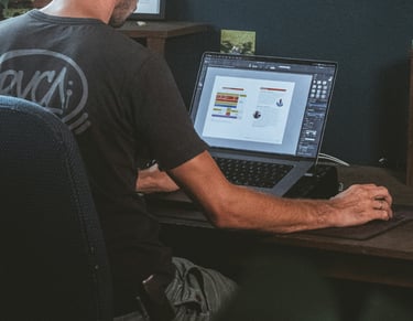 a man sitting at a desk with a laptop computer designing