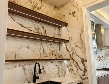 Modern bar niche with book-matched marble backsplash, floating wood shelves with built-in lighting, 