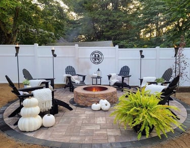 a patio with a fire pit and chairs