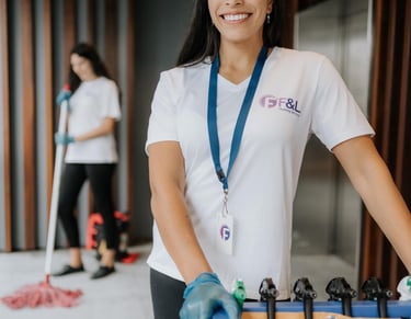 a woman in a white shirt and gloves holding a box of cleaning supplies