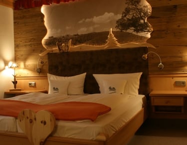 Hotelzimmer mit liebevollen Holzdetails in der Köhlerhütte Fürstenbrunn