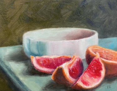 An original oil painting of a grapefruit which has been halved and sliced in front of a bowl