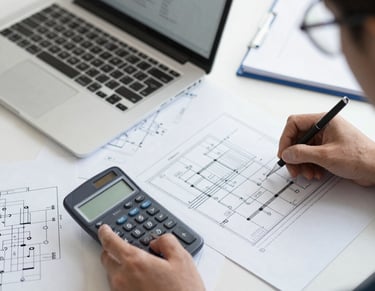 Engineers collaborating on an electrical system blueprint in an office.