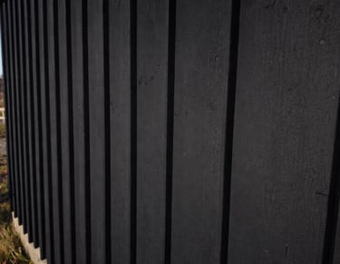 Matte black exterior wood siding finished with breathable heritage paint