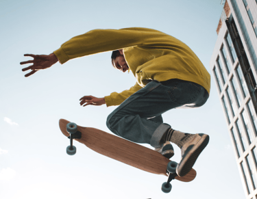 a man in a yellow shirt is doing tricks on a skateboard
