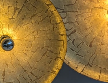 two large gold colored lamps with a gold colored lamp