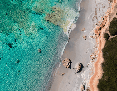 a beach with a beautiful water in the mediterrean sea
