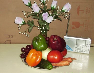 A flower bottle and a plate of vegetable and fruits, a