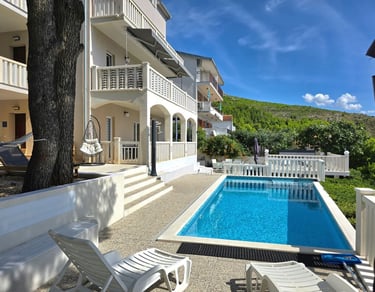 The photo depicts the house and yard with the pool as seen from the western sunny terrace.