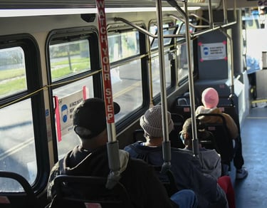 Photo taken inside of a bus of public transit riders