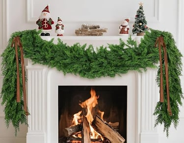 fireplace with green artificial garland and Christmas decorations