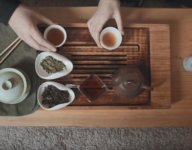 Tea set on the table with two people drinking tea