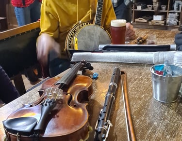Traditional Irish music session featuring a fiddle, flute, and banjo on a pub table.