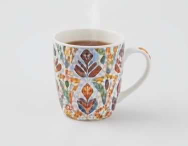 A high-quality ceramic mug decorated with a complex, colorful botanical pattern in warm and cool shades.