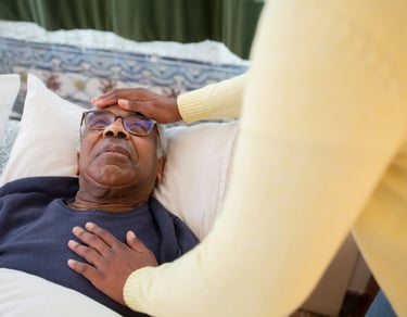 a man in glasses and a sweater is laying on a bed