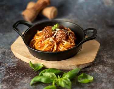 Professional food photography of spaghetti meatballs served in a iron pan - menu content creation