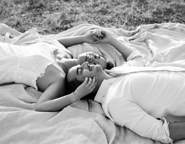 Black and white couple portrait — lying back head to head in a peaceful Provence setting