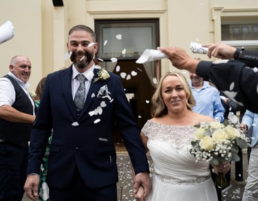 Newly married couple smiling during confetti 