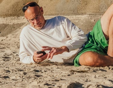 Uomo maturo in viaggio che controlla lo smartphone per restare connesso e gestire situazioni a dista