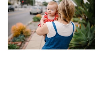 Mother walking down the street carrying baby