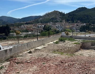 Vue panoramique d’un village espagnol niché dans des collines verdoyantes sous un ciel bleu