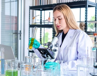 Profissional mulher biomédica fazendo análises de amostras clínicas.