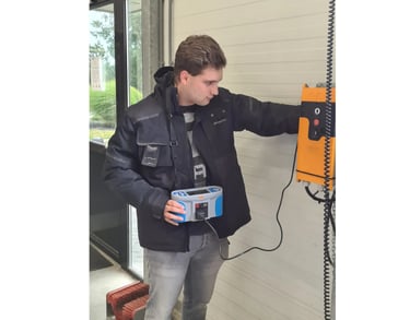 Inspecteur test elektrische laadinstallatie met meetapparatuur in industriële omgeving