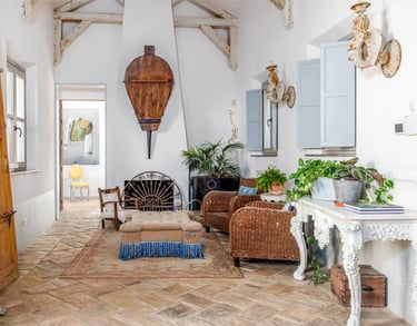 Rustic lounge with wicker chairs and fireplace at Finca Santa Katerina