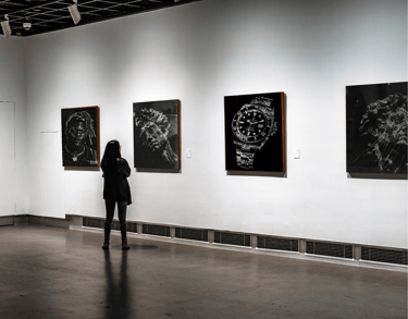 a person standing in front of a wall with paintings