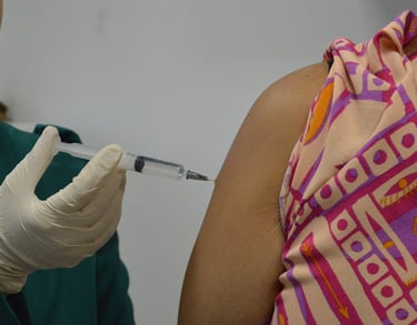 Professora farmacêutica ensinando a técnica para aplicação de injetáveis pela via intramuscular.
