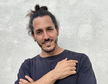 Borja Llegó posando de brazos cruzados frente a una pared gris, creador de contenido de viajes y gas