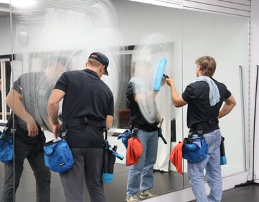 the owners of spartan window cleaning, cleaning a mirror