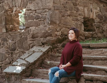 Photo of author Courtney J. Hall sitting on stone steps