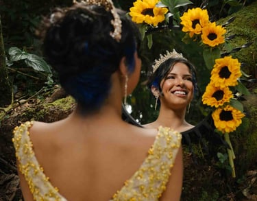 Foto creativa de quinceañera de piel oscura, vestido dorado viéndose al espejo rodeado de girasoles bosque Quito Ecuador