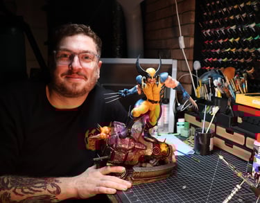 Ryan hand-painting a Wolverine statue at the Heavy Handed Studio workbench