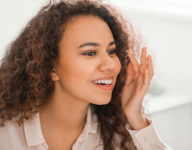 Woman smiling while putting in a contact lens