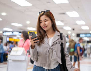 a woman in a gray jacket and sunglasses is holding a cell phone