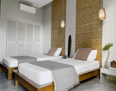 a bedroom with two beds and a surfboard