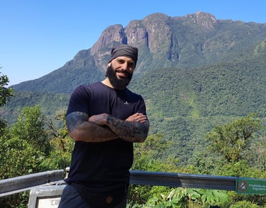 um personal trainer de braço cruzados em frente a montanha