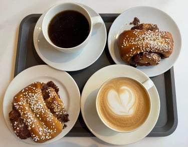 a tray with two cups of coffee and two pastries